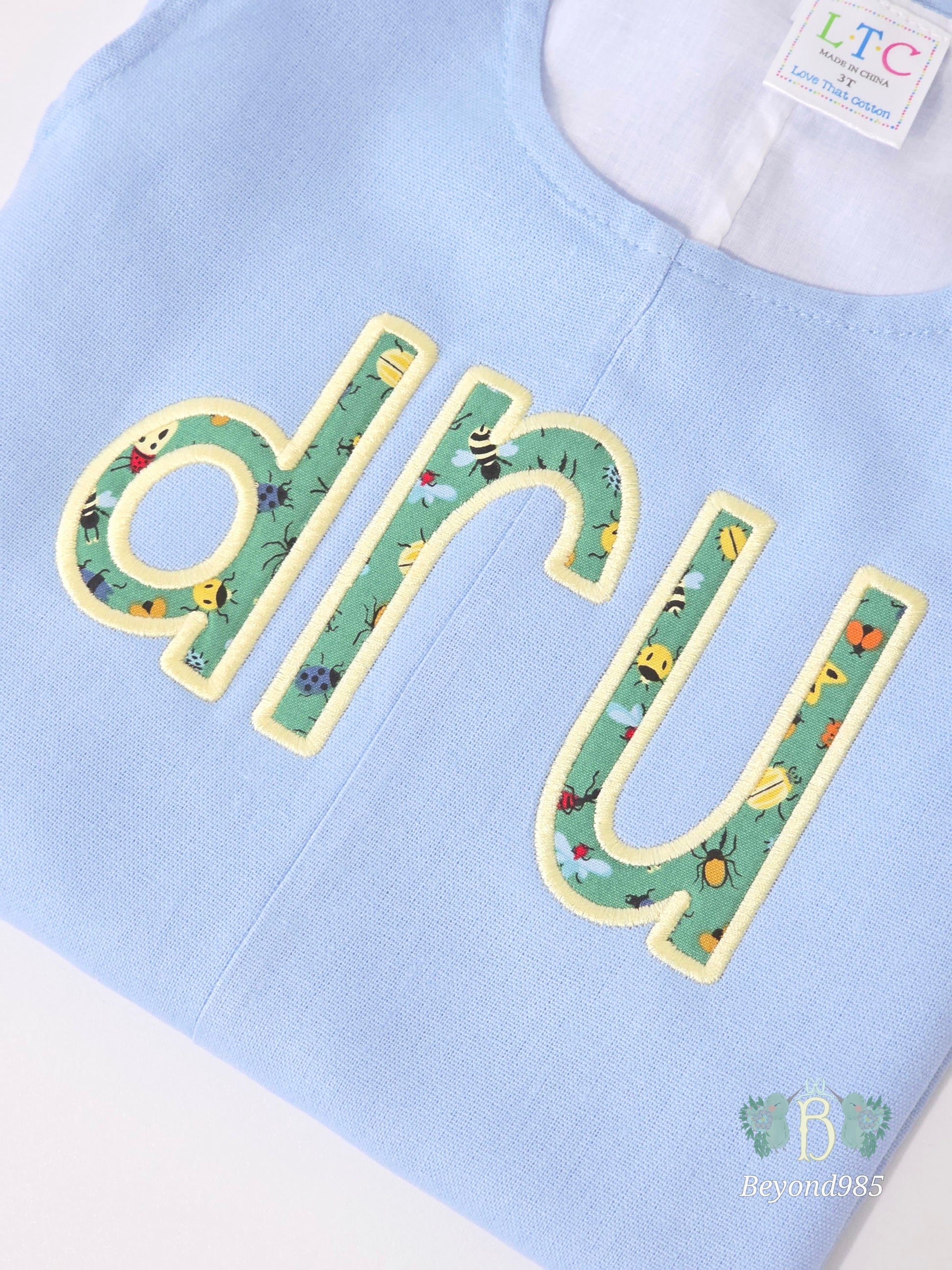 Detail of personalized applique name embroidery on boys summer shortall