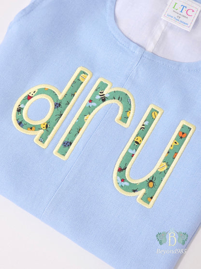 Detail of personalized applique name embroidery on boys summer shortall
