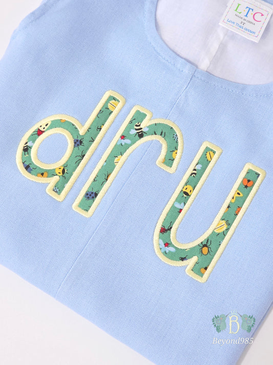 Detail of personalized applique name embroidery on boys summer shortall