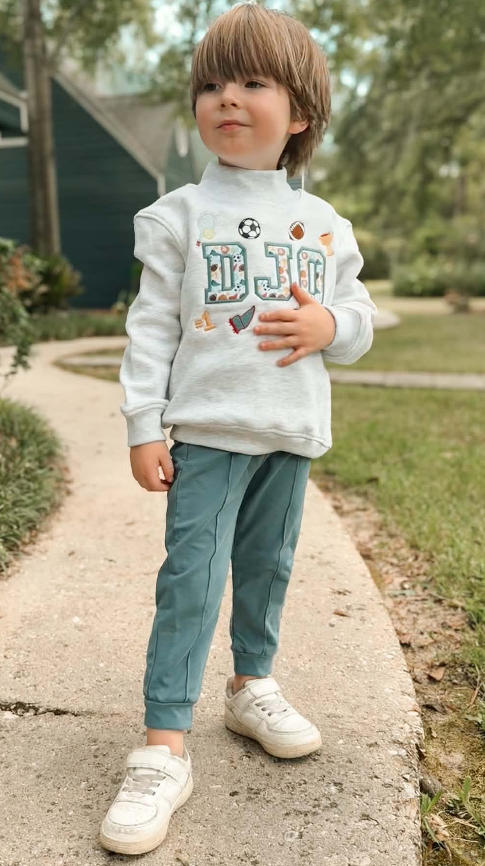 Boy wearing personalized 100% cotton mock neck sweatshirt with vintage sports appliqué name