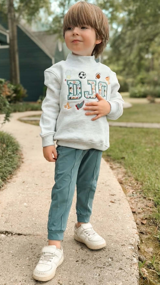 Boy wearing personalized 100% cotton mock neck sweatshirt with vintage sports appliqué name