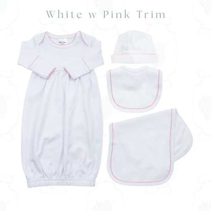 A baby clothing set laid out on a white background, including a long-sleeve footmuff in white with pink trim, a bonnet, a bib, and a footstool, with the text 'White w Pink Trim' at the top.