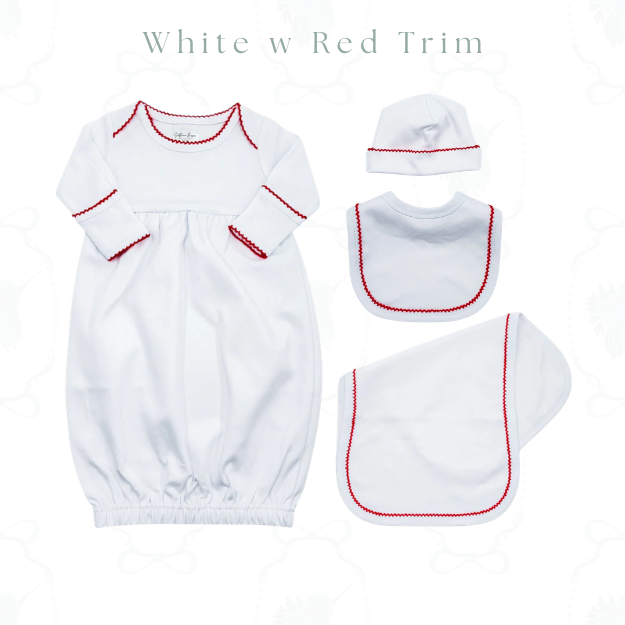 A baby clothing set laid out on a white background, including a long-sleeve white footmuff with red trim, a white bonnet with red trim, a white bib with red trim, and a white footstool or blanket with red trim. Text at the top reads 'White w Red Trim'.