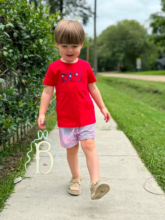 Toddler boy wearing personalized red patriotic embroidered shirt with red white and blue plaid shorts